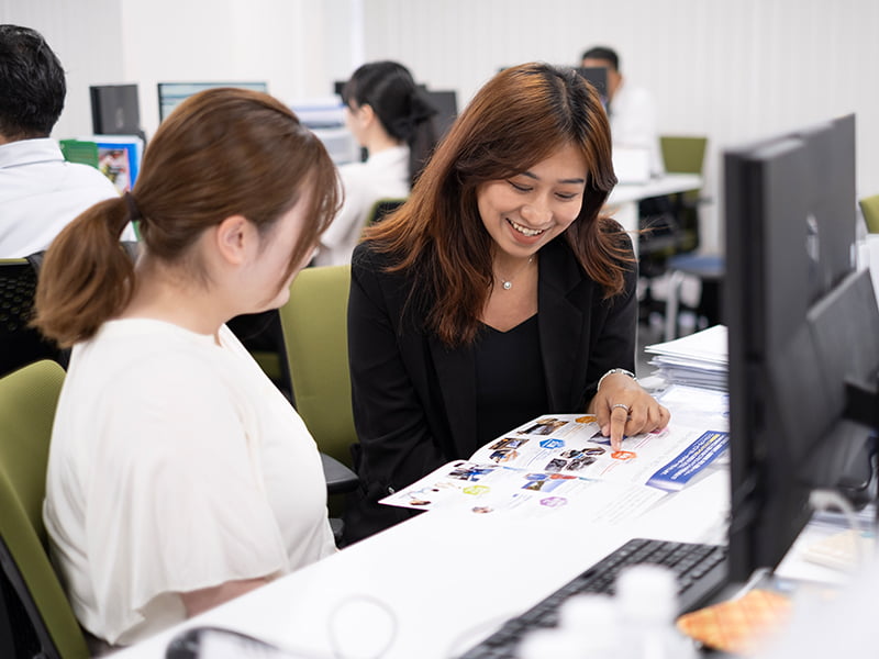 デスクで打ち合わせをするスタッフの写真