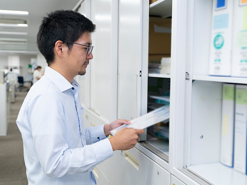 ラックに書類を収納するスタッフの写真